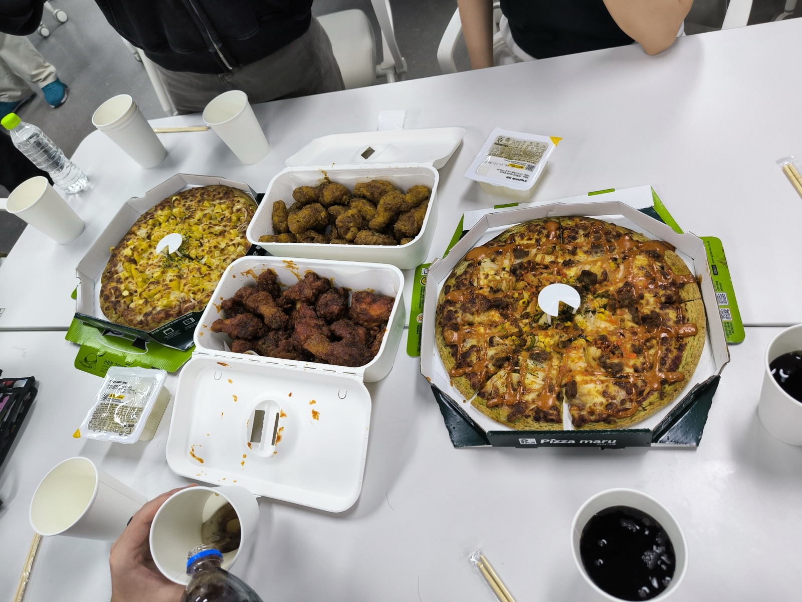 A spread of Korean-style pizza and fried chicken on the table