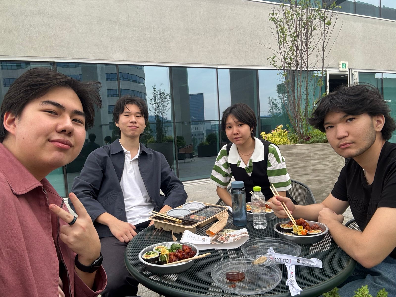 Students sharing lunch at an outdoor table on the AI Hub terrace