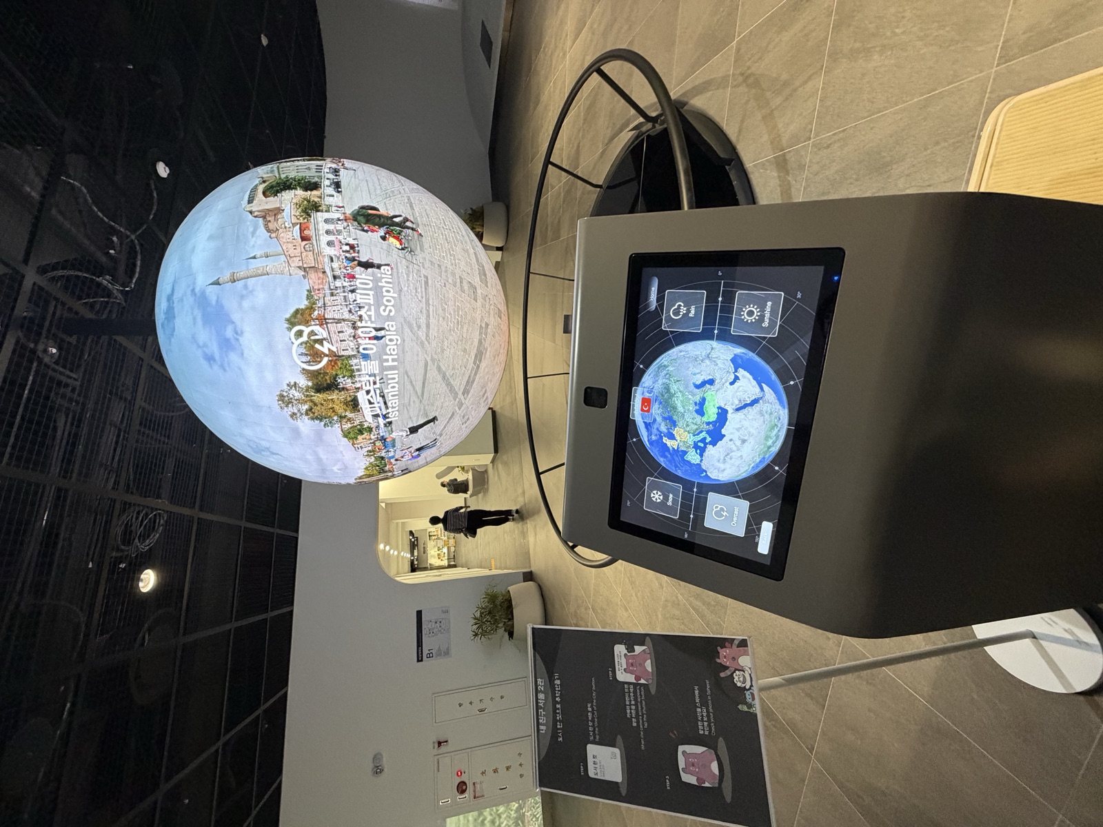 An interactive spherical-screen globe exhibit with a touch panel