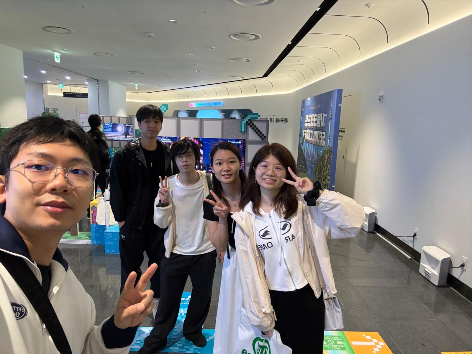 An arrival selfie of students in the bright gallery lobby