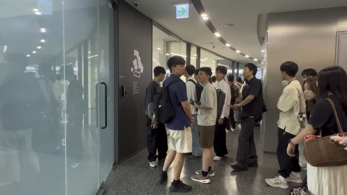 Filing through a glass-walled corridor on the way to the library