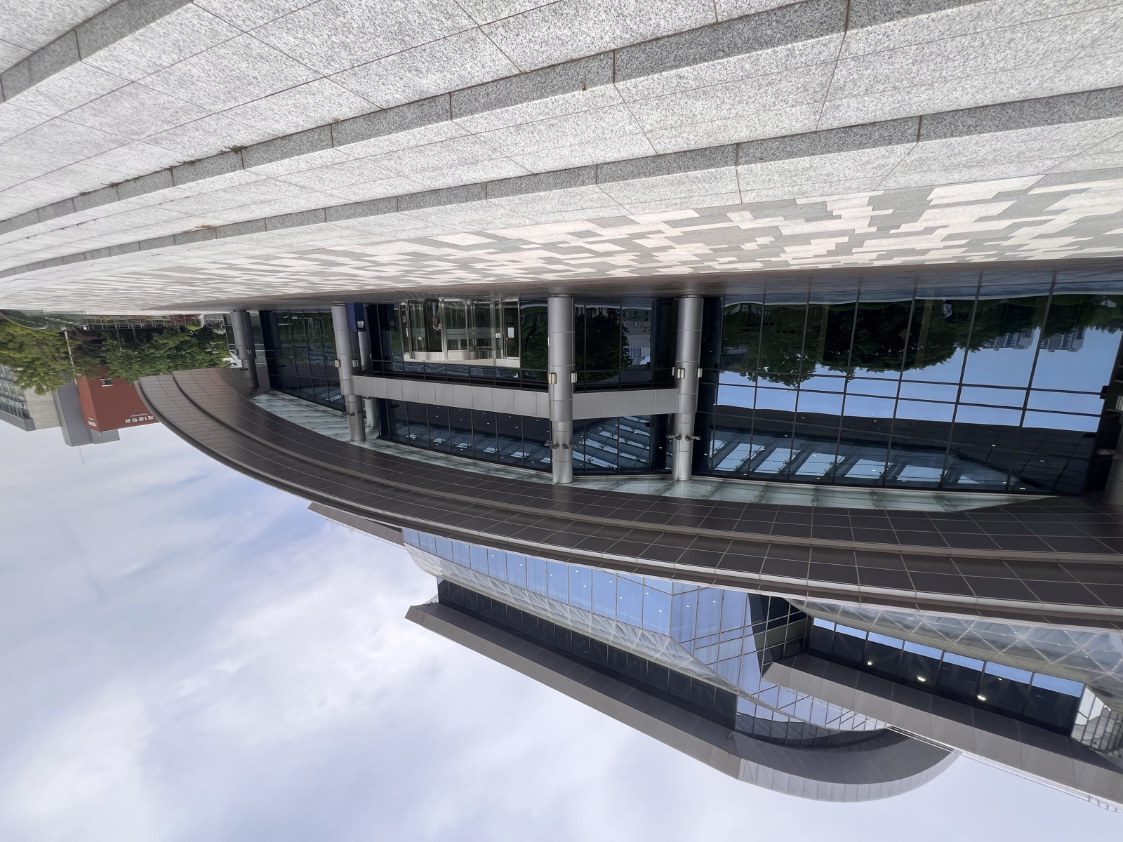 The landmark curved, all-glass library exterior rising over its stone plaza