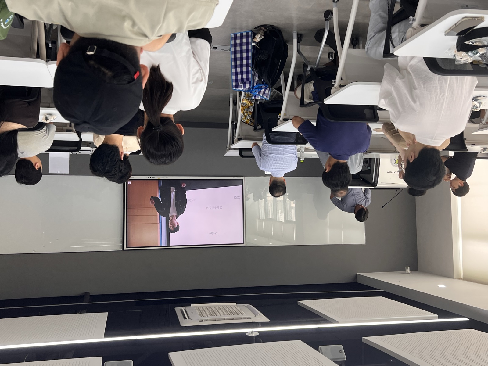 The group watching the intro video on the seminar room's big screen