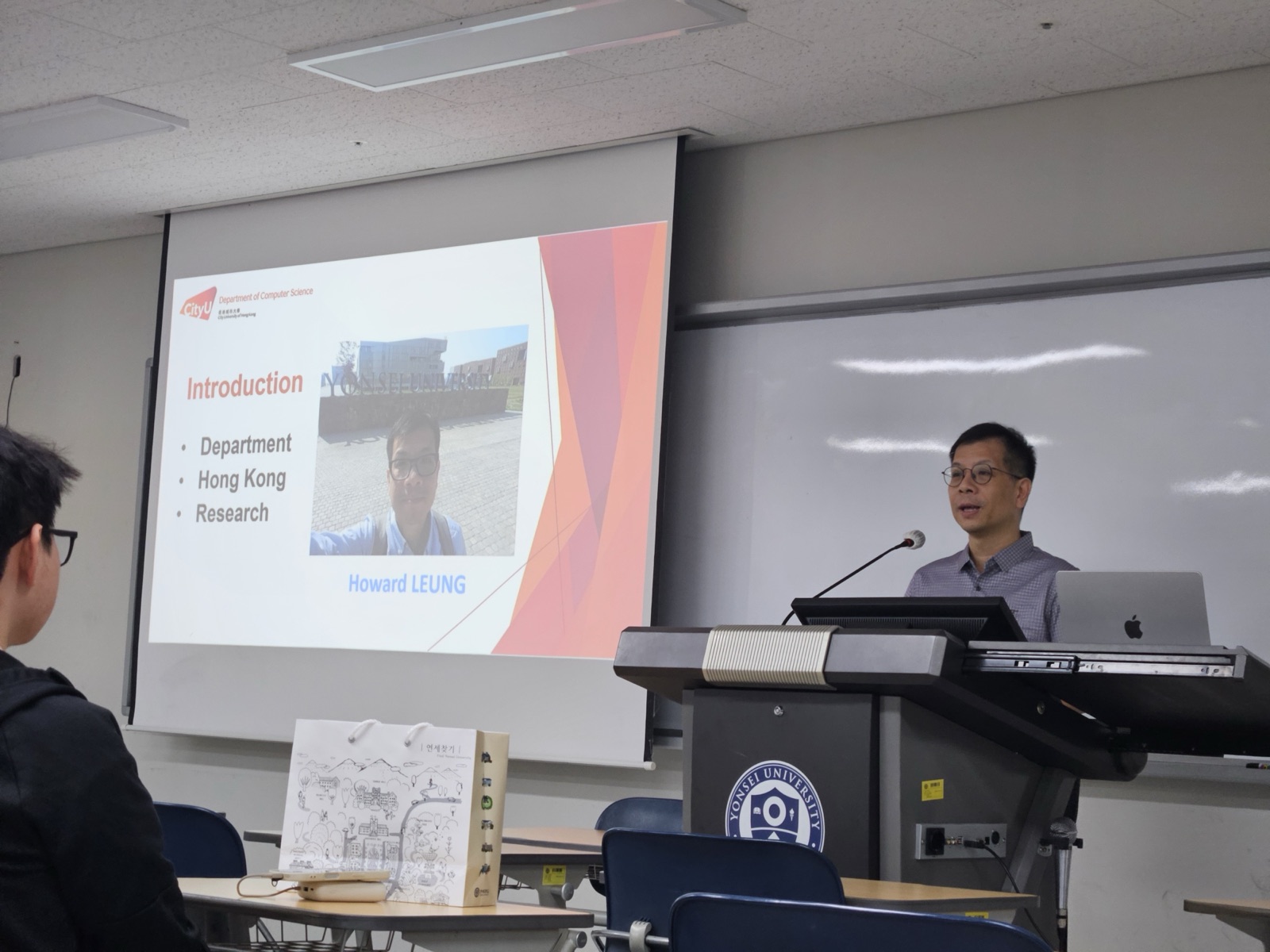 Prof. Howard Leung at the podium beside an Introduction slide